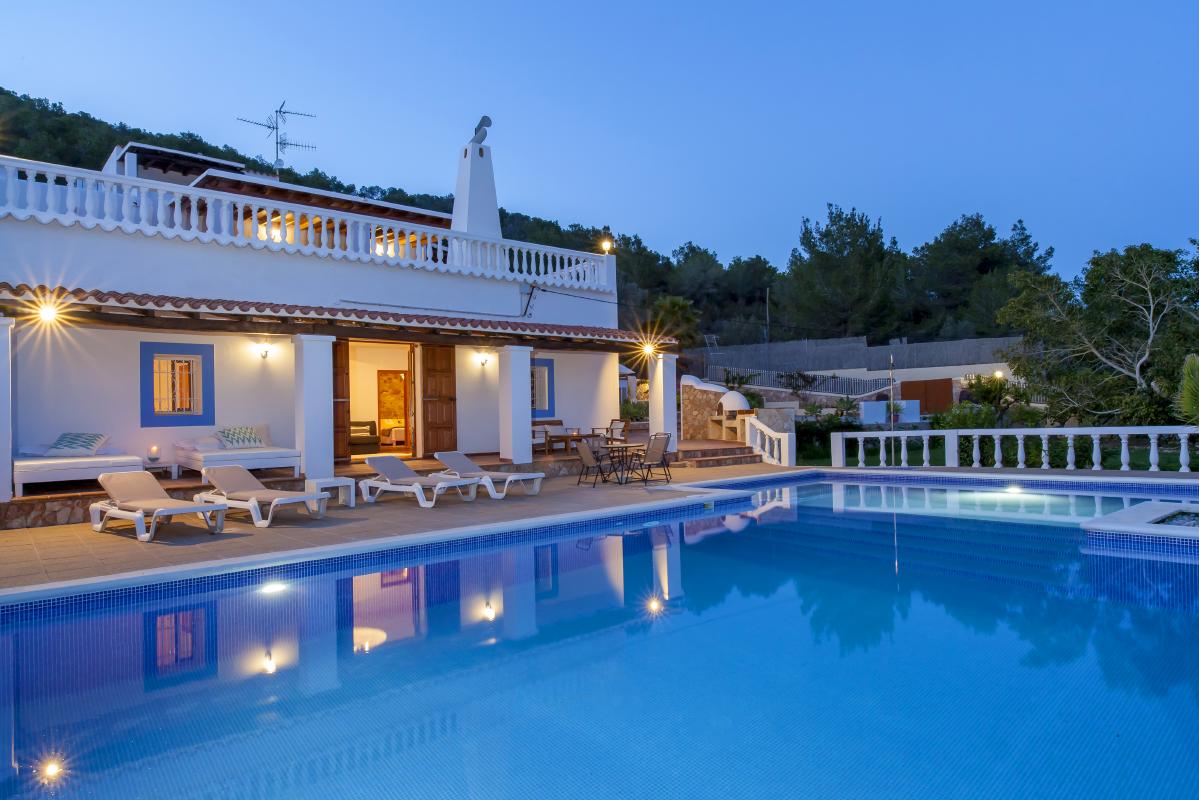 Exterior of house rental at night pool and lighted outdoor areas